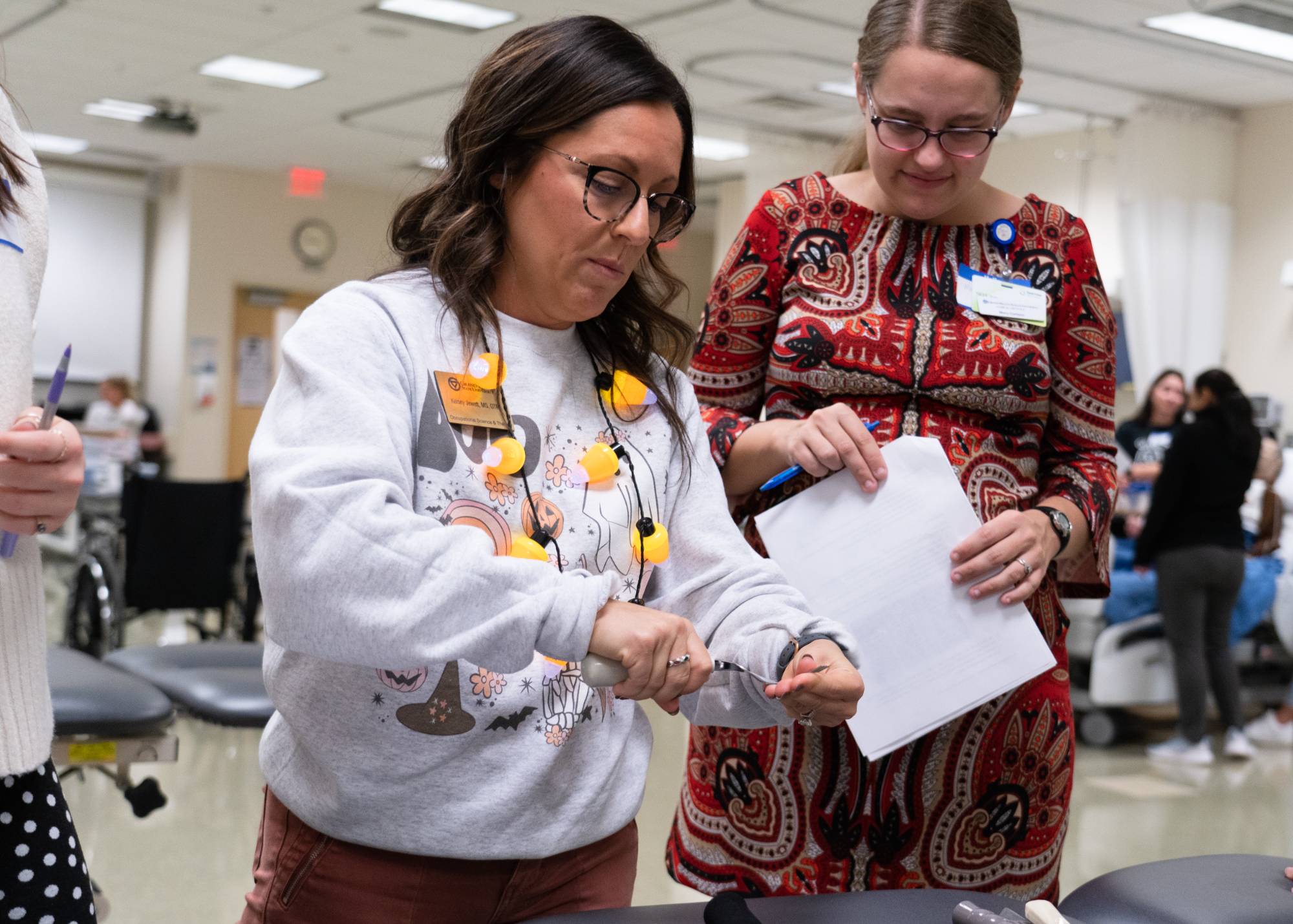 OT instructor displaying weighted and comfort grip utensil